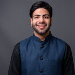 Studio shot of young handsome Indian businessman against gray background